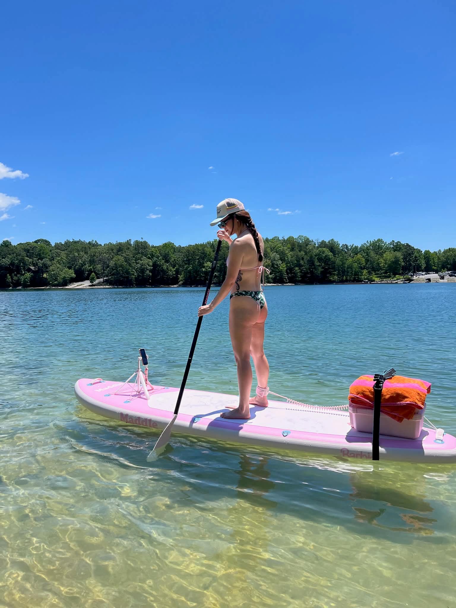 Woman paddleboarding on calm turquoise water in Wilmington